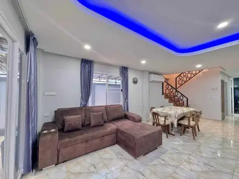 4 Bedroom House for Rent in East Pattaya living room with brown sofa and blue accent ceiling lighting