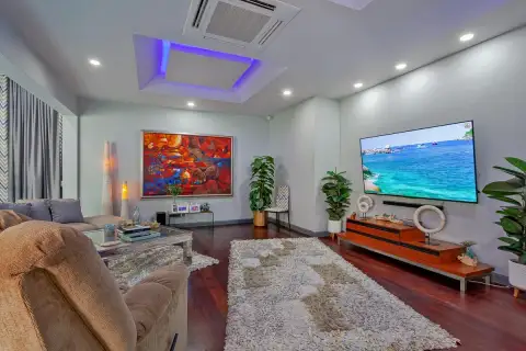 5 Bedroom House for Sale & Rent in Pratumnak Hill living room with red abstract painting, large flat-screen TV, dark hardwood floors and shag rug