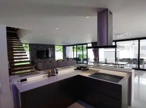 7 Bedroom House for Sale & Rent in Pratumnak Hill modern kitchen island with built-in stove and glass walls overlooking garden