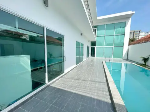 6 Bedroom House for Sale & Rent in Pratumnak Hill poolside walkway along glass doors and green facade