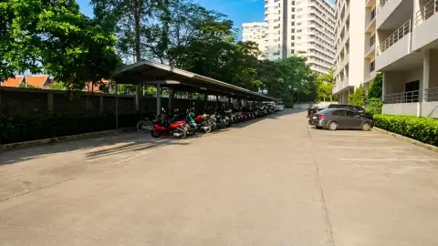 View Talay 3A covered parking area with cars, motorbikes and jet ski near residential building