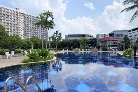 Rimhad Jomtien Condominium S2 pool deck with loungers, greenery and nearby buildings