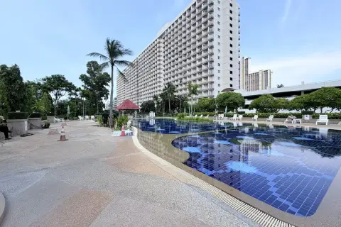 Rimhad Jomtien Condominium S2 poolside deck with loungers and view of residential tower