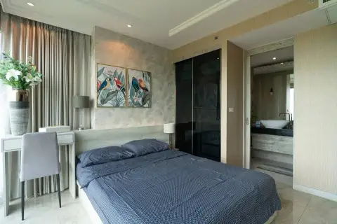 2 Bedroom Condo for Sale at Riviera Monaco master bedroom with navy bedding and tropical wall art