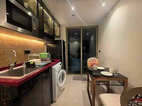 1 Bedroom Condo for Rent at Riviera Ocean Drive kitchenette with washing machine and dining table by balcony