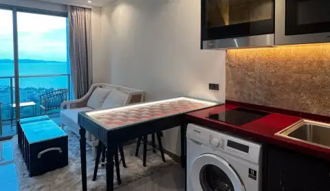 1 Bedroom Condo for Sale at Riviera Ocean Drive open-plan kitchen and living area with ocean view balcony