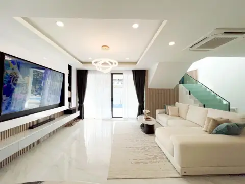 5 Bedroom House for Rent in Jomtien bright living room with sectional sofa and glass staircase
