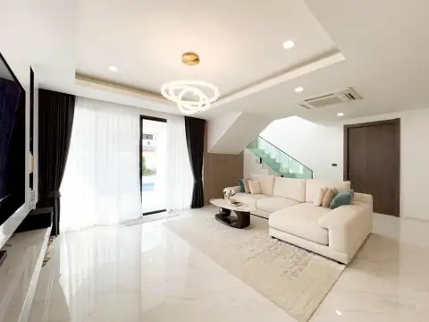 5 Bedroom House for Rent in Jomtien lounge space with beige sofa and view to pool area