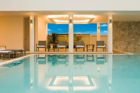 Sea Breeze Villa Pattaya covered poolside lounge area with illuminated ceiling and reflections in the water.