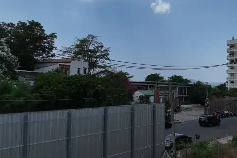 1 Bedroom Condo for Sale at Sea Sky By Sand exterior street view with nearby houses, trees, and construction fence