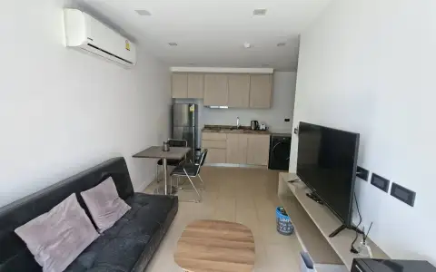 2 Bedroom Condo for Sale at Sea Zen living area with black sofa, dining set and compact kitchen view