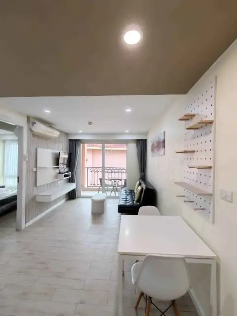 1 Bedroom Condo for Sale at Seven Seas Condo Resort open-plan living room with sofa, TV unit and balcony access