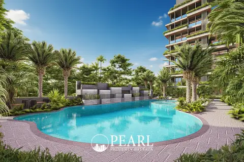 Siam Oriental Oasis resort-style swimming pool with waterfall feature, surrounded by lush tropical foliage and lounge chairs.