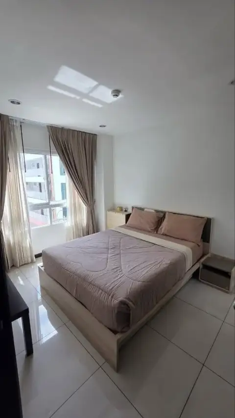 1 Bedroom Condo for Sale at Siam Oriental Tropical Garden bedroom with double bed and city-view window