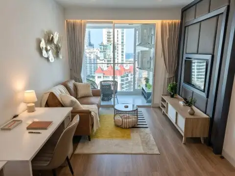 1 Bedroom Condo for Sale at Sky Residences Pattaya living room with sofa, TV unit and balcony city view