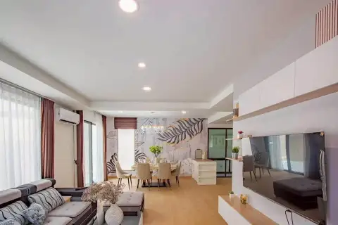 4 Bedroom House for Rent in Takhian Tia open-plan living and dining area with leaf-pattern accent wall