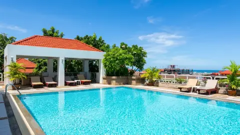 Pattaya Hill Resort rooftop pool with orange-roofed pavilion and distant sea view
