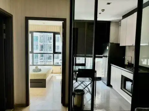 1 Bedroom Condo for Sale at The Base Central Pattaya hallway view into bedroom and glass-enclosed kitchen