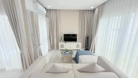 3 Bedroom House for Rent at The Palm Grandio's living room with beige curtains, TV console and cream sofa