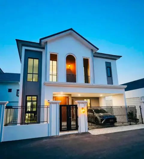 3 Bedroom House for Rent at The Palm Grandio's exterior view at dusk with warm interior lighting and gated driveway