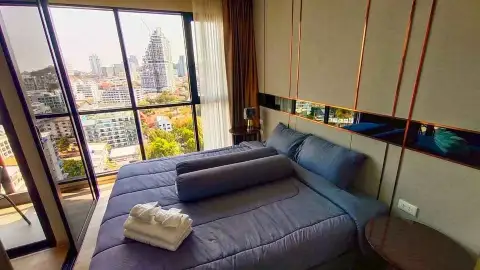 1 Bedroom Condo for Rent at The Panora Pattaya bedroom with blue bedding and panoramic floor-to-ceiling window city view
