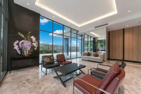 The Point Pratumnak modern lobby lounge with marble floors, dark accent walls, and comfortable seating.