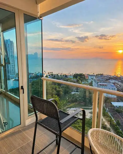 2 Bedroom Condo for Rent at The Riviera Jomtien private balcony with rattan chairs overlooking ocean sunset