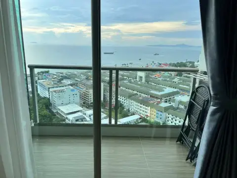 Studio Condo for Rent at The Riviera Jomtien sea view from balcony with folding chairs and cityscape