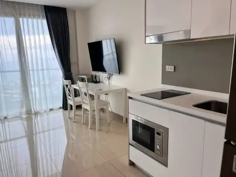 Studio Condo for Rent at The Riviera Jomtien kitchen counter with stove, sink, and dining area