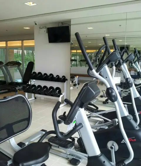 The Trust Condo South Pattaya gym area with elliptical trainers, dumbbell rack, and treadmill