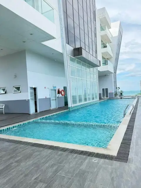 1 Bedroom Condo for Sale at The Vision outdoor swimming pool alongside building facade and ocean backdrop