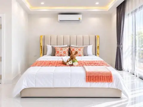 3 Bedroom Townhouse for Rent in East Pattaya master bedroom with beige upholstered bed and orange accents