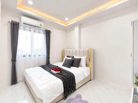 3 Bedroom Townhouse for Rent in East Pattaya cozy bedroom with gray curtains and tufted headboard
