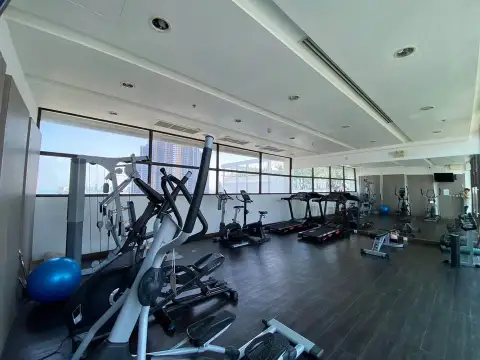 Treetops Condo gym interior with cardio machines, weights, and wooden flooring