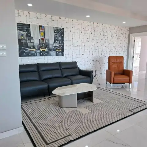 3 Bedroom Condo for Sale at Tropicana Pratumnak living room with black leather sofa and orange armchair