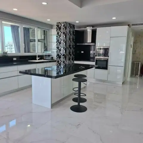 3 Bedroom Condo for Sale at Tropicana Pratumnak modern kitchen with white cabinetry and black countertop island