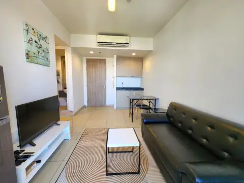 1 Bedroom Condo for Sale & Rent at Unixx South Pattaya open-plan living room with kitchenette and TV unit