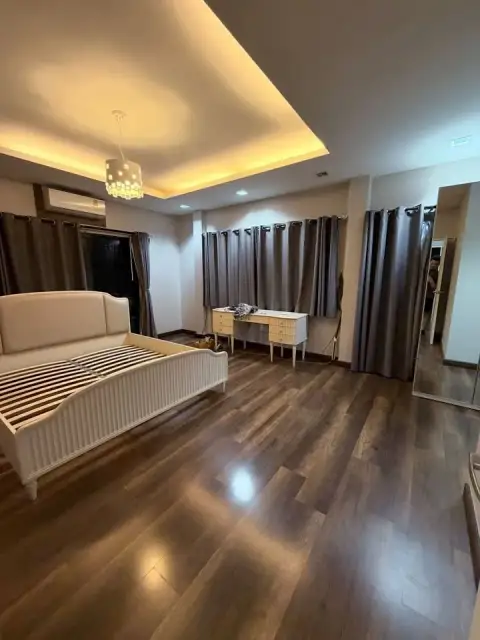 4 Bedroom House for Rent in East Pattaya primary bedroom with wood flooring and tray ceiling lighting