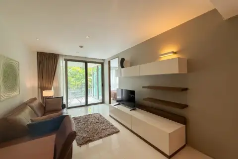 2 Bedroom Condo for Sale & Rent at The Sanctuary Wongamat living room with modern TV wall unit and sliding door balcony