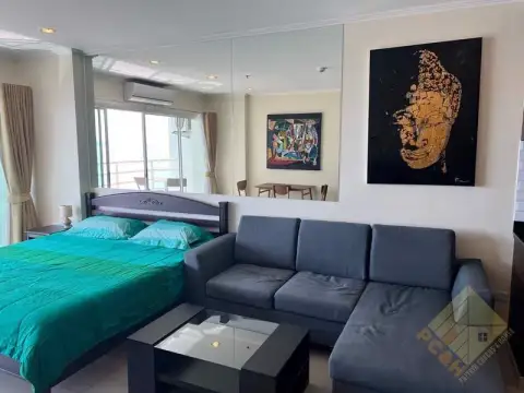 1 Bedroom Condo for Sale at View Talay 7 living area with sofa, bed and wall art near mirrored wall