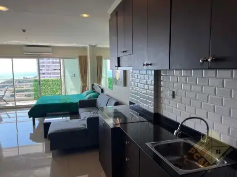 1 Bedroom Condo for Sale at View Talay 7 kitchenette with black countertop and ocean-view balcony beyond
