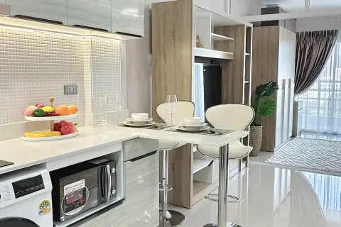 1 Bedroom Condo for Sale at View Talay 8 open-plan living area with bed, beige sofa, and city view window