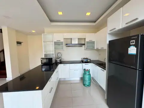 4 Bedroom House for Sale at Villa Asiatic modern kitchen with black countertops, white cabinets, and fridge