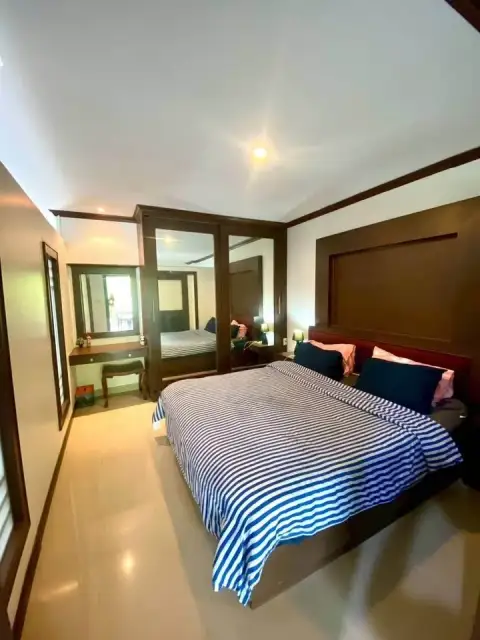 1 Bedroom Condo for Sale at Wongamat Privacy bedroom with striped bedding and mirrored closet