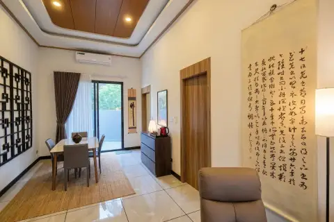 Amarin House 2 elegant dining area with wood-panel tray ceiling, Asian calligraphy decor, and sliding garden door