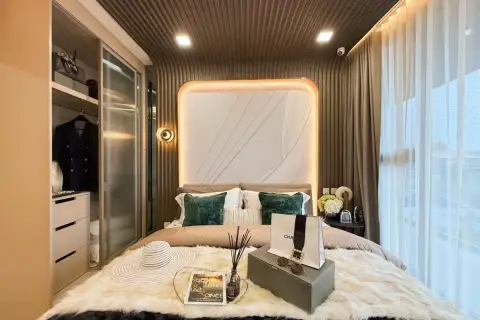 2 Bedroom Condo for Sale at Aquarous Jomtien Pattaya cozy living room with wood-panel TV unit, sofa, and balcony with city view