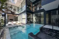 6 Bedroom House for Sale in Bang Lamung modern exterior with swimming pool, glass walls, and sun loungers.