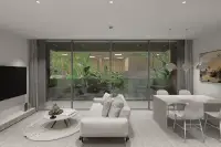 2 Bedroom Condo for Sale at Celine Wongamat modern living and dining area with panoramic glass doors overlooking lush garden
