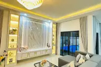 4 Bedroom House for Sale at Rattanakorn Village 18: Living room with a large TV wall unit, sectional sofa, and pool view.