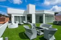 5 Bedroom House for Rent at Casa Jomtien rooftop terrace with rattan lounge furniture, sunbeds, and round jacuzzi